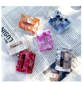 Detailed close-up of six assorted marble-textured acetate hair claws with metal springs