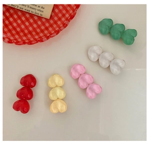 Close-up of colorful resin heart hair clips with matte finish in five sweet colors