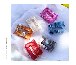 Detail of medium acetate hair claws in various marble textures and hollow geometric designs