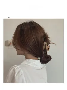 Detail of large square hair claw clip with floral tortoiseshell pattern on hair bun