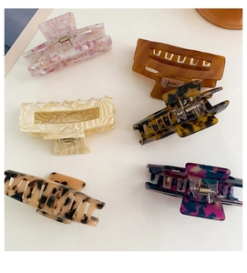 Detail of six large square hollow hair claws in floral and marble acetate textures