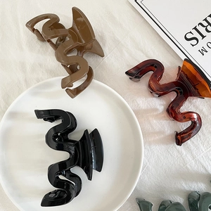 Minimalist large wavy shark hair clips in black, brown and amber for stylish hair styling