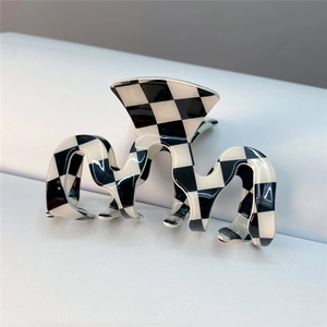 Irregular black and white checkerboard acetate hair claw clip with glossy finish