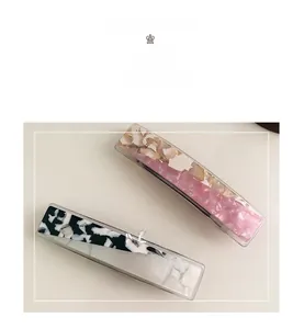 Detail of pink cream and marble pattern acetate hair clips with spring fasteners