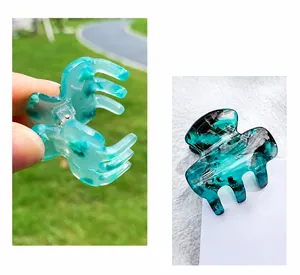 Detail showing marble texture of mint and dark green acetate hair claw clips