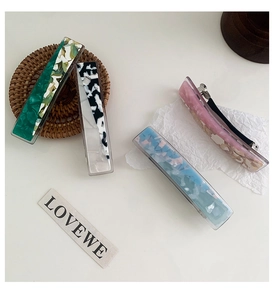 Close-up of elegant marble pattern acetate hair clips with spring metal backing