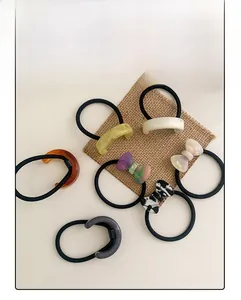 Detailed set of 7 acetate hair ties with bow and marble patterns on cream linen base