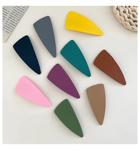 Detailed close-up of nine-piece matte geometric triangular hair clips in assorted colors