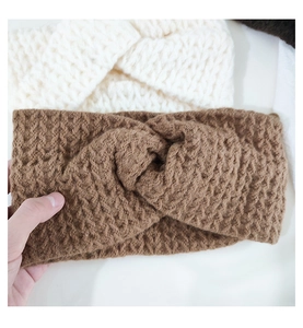 Close-up of knit twisted headband with waffle texture in cream and brown colors