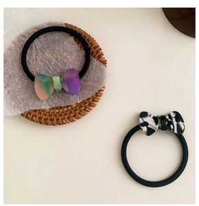 Close-up of acetic acid bow hair ties with marble pattern and gradient finish