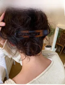 Détail d'une pince à cheveux en écaille de tortue portée sur un chignon bas chic