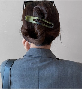 Détail d'une pince à cheveux mate en acrylique dégradé vert foncé et noir
