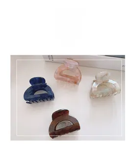 Selection of acetate hollow hair claws in tortoiseshell and floral patterns on table