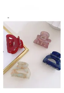 Detail view of acetate hair claws in assorted marble textures and hollow geometric designs