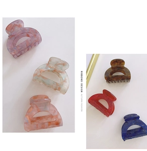 Collection of six colored acetate hair claws showing diverse marble patterns and glossy finish