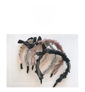 Close-up of pleated chiffon ribbon headband with rhinestone details and soft fabric texture