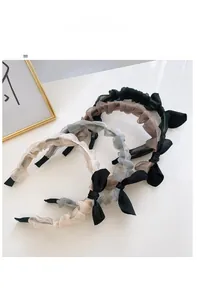 Detailed macro view of four pleated chiffon headbands with bunny ear bows in neutral colors