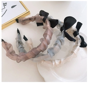 Close-up detail of pleated chiffon headbands with elegant black ribbon bow accents