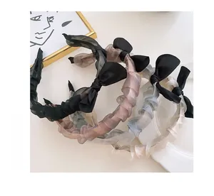 Detail of four pleated chiffon bunny ear headbands in black pink grey and beige colors