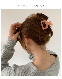 Vue détaillée d'une pince à cheveux carrée rose corail portée sur une queue de cheval