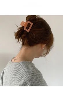 Détail d'une pince à cheveux rectangulaire pêche mate fixant un chignon