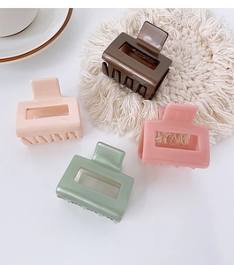 Vue détaillée de pinces à cheveux carrées en acétate aux couleurs café, rose et vert