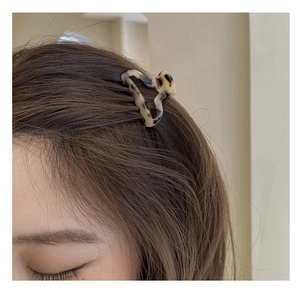 Detail view of a vintage tortoiseshell hair claw clip styled on long brown hair