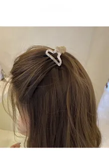 Detailed back view of a creamy white hollow heart acetate hair claw clip on model