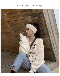 Dettaglio della fascia in lana lavorata a maglia color crema con felpa casual stampata