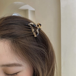 Small heart-shaped tortoise shell acetate hair claw clip worn on brunette hair
