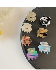 Detailed overhead view of seven mini acetate hair claws in various marble and floral patterns
