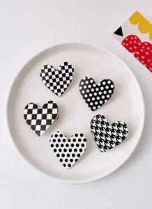Detailed set of five heart-shaped hair clips featuring classic black and white patterns