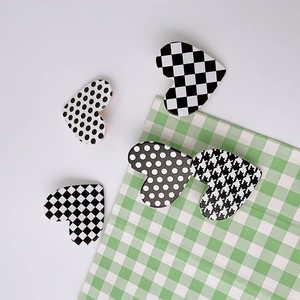 Five heart-shaped hair clips with black and white checkered and polka dot patterns