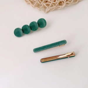 Driedelige donkergroene fluwelen haarclips set met gouden metalen basis op witte achtergrond