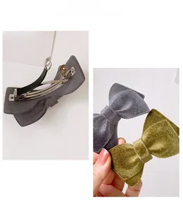 Detail of velvet bow hair clips with metal spring fasteners in grey and green