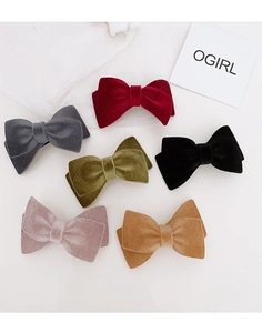 Detailed overhead view showing velvet bow hair clips in six elegant seasonal colors