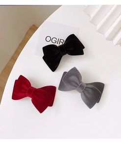 Three elegant velvet bow hair clips in black, wine red, and grey on a white background