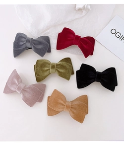 Detailed flat lay of velvet bow hair clips in six vintage colors on white background