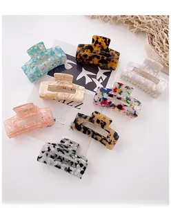 Flat lay of eight hollow rectangle acetate hair claws in various marble and floral patterns