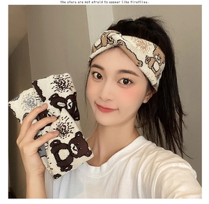 Detail showing knit texture and brown bear pattern on cream knotted headband
