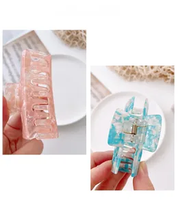 Detail view of pink and blue acetate hair claws with marble texture and metal spring