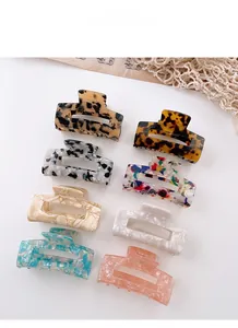 Flat lay of 8 large acetate hair claws featuring tortoiseshell and marble patterns