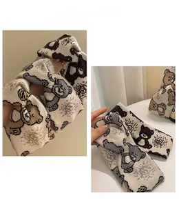Detail showing knitted beige headband with cute bear pattern and twist knot texture