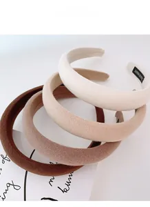 Close-up of four thick sponge headbands in gradient earth tones with handmade labels