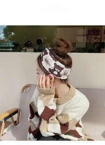 Detail of soft knitted bear pattern headband worn by a model in a cozy cafe setting
