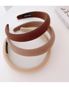 Close-up of three thick sponge headbands in brown tones with fine diagonal texture fabric