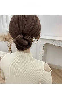 Eleganter Haarnadel aus Goldmetall mit großer weißer Perle in einem stilvollen Dutt