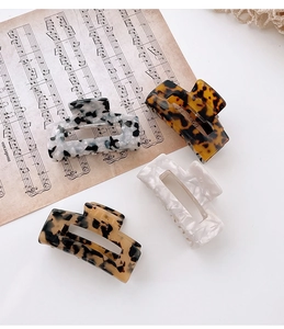 Set of four acetate claw clips with marble and tortoise patterns in a hollow rectangle design