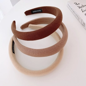 Three earth-toned thick sponge headbands with twill texture and handmade woven label