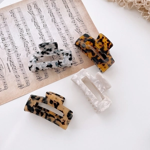 Set of four hollow rectangular acetate hair claws in tortoise shell and marble patterns